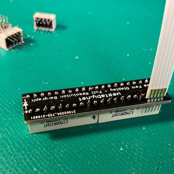 Two boards aligned with ribbon cable inserted before bending